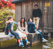 Stylische Menschen sitzen zusammen und tragen bunte Socken von We are Socks!